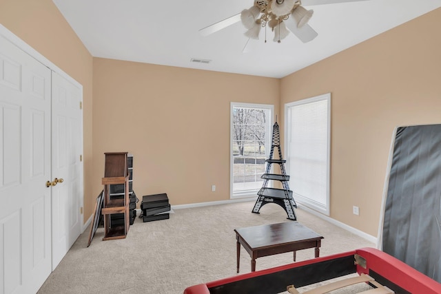 sitting room with ceiling fan and light carpet