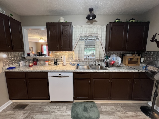 kitchen with dark brown cabinetry, white dishwasher, sink, a textured ceiling, and backsplash