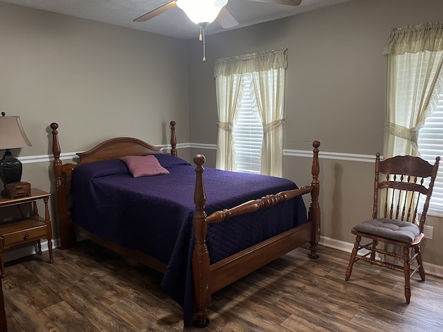 bedroom with ceiling fan, dark hardwood / wood-style floors, and multiple windows