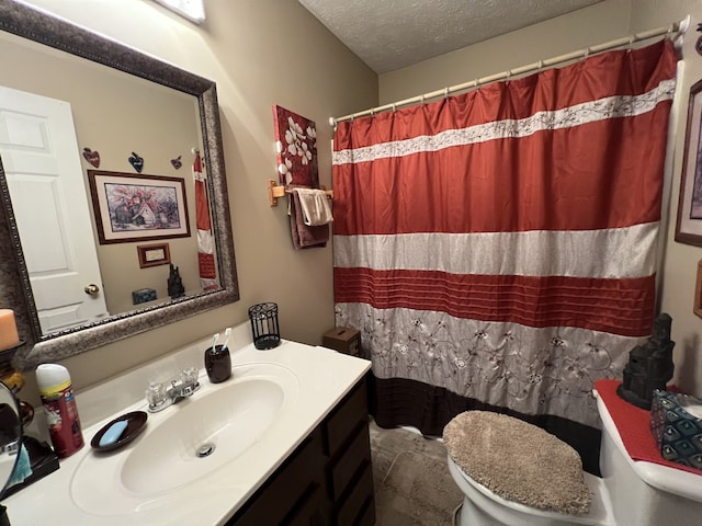 bathroom featuring walk in shower, vanity, toilet, and a textured ceiling