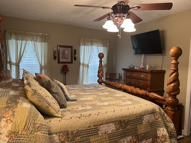 bedroom featuring wood-type flooring, a textured ceiling, and ceiling fan