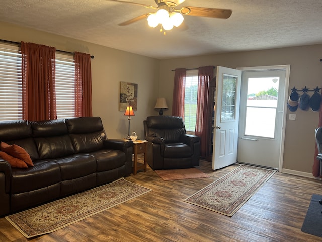 living room featuring ceiling fan, plenty of natural light, hardwood / wood-style floors, and a textured ceiling