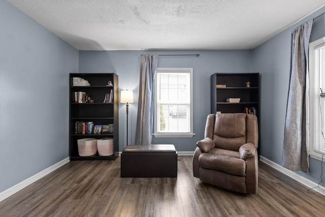 sitting room with a textured ceiling and dark wood-type flooring