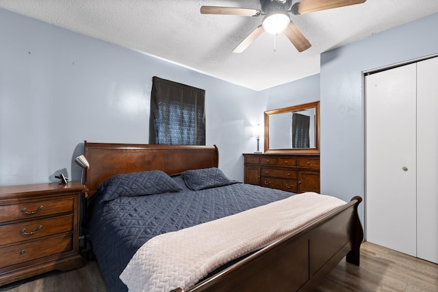 bedroom featuring hardwood / wood-style flooring, ceiling fan, a textured ceiling, and a closet