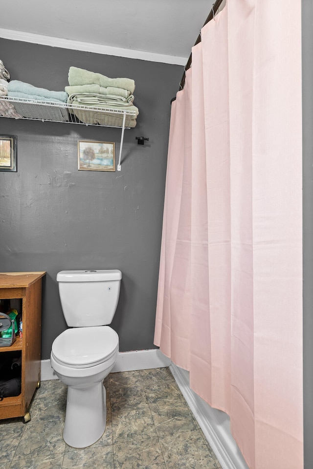 bathroom featuring shower / bath combination with curtain, ornamental molding, and toilet