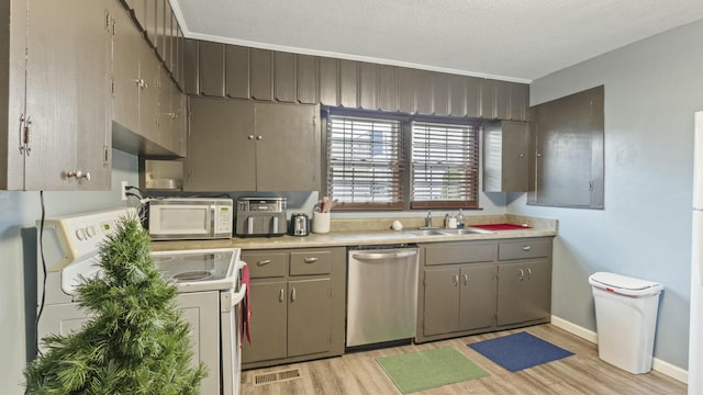 kitchen featuring a textured ceiling, white appliances, light hardwood / wood-style floors, and sink