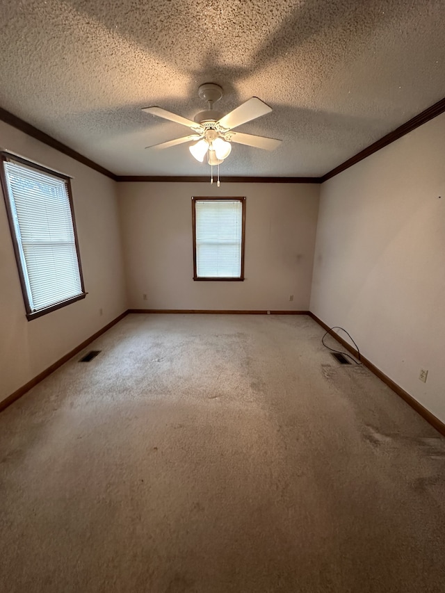 spare room featuring ceiling fan, a textured ceiling, carpet flooring, and a healthy amount of sunlight