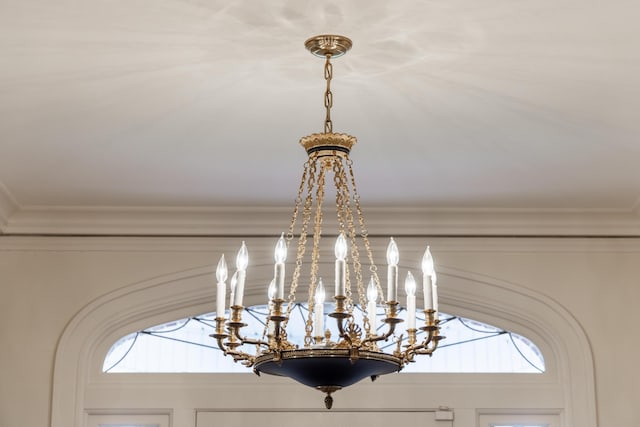 interior details featuring ornamental molding and a chandelier