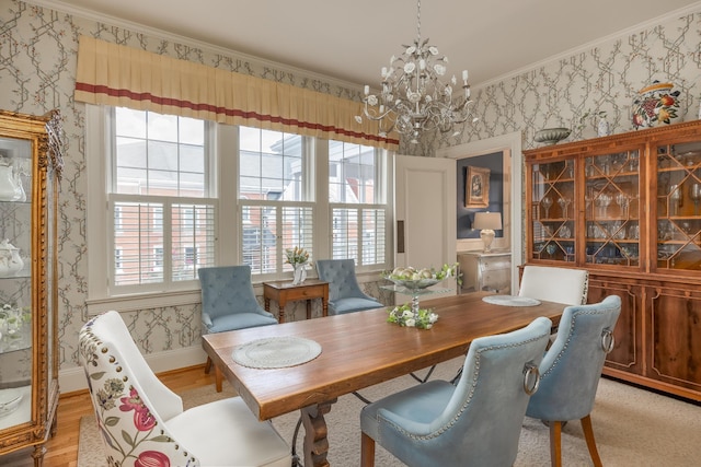 dining space featuring a notable chandelier, light hardwood / wood-style flooring, and crown molding