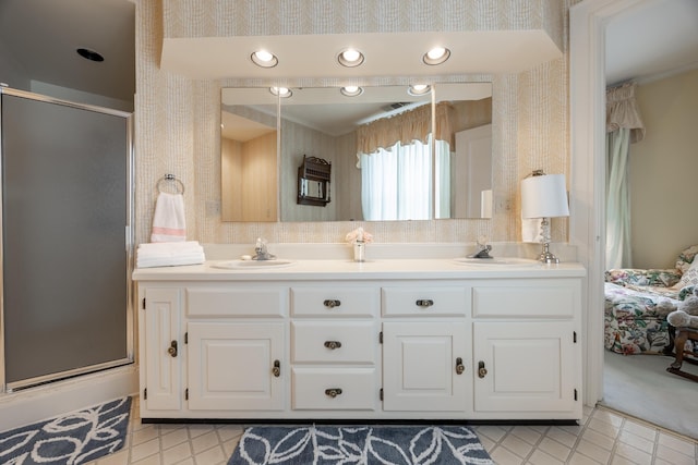 bathroom featuring a shower with door and vanity