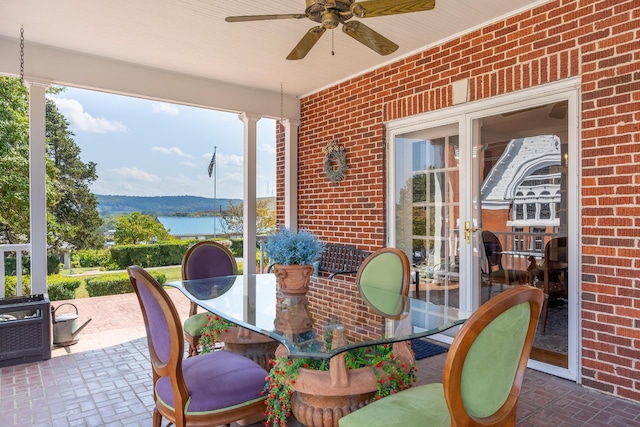 sunroom with a water view, ceiling fan, and a healthy amount of sunlight