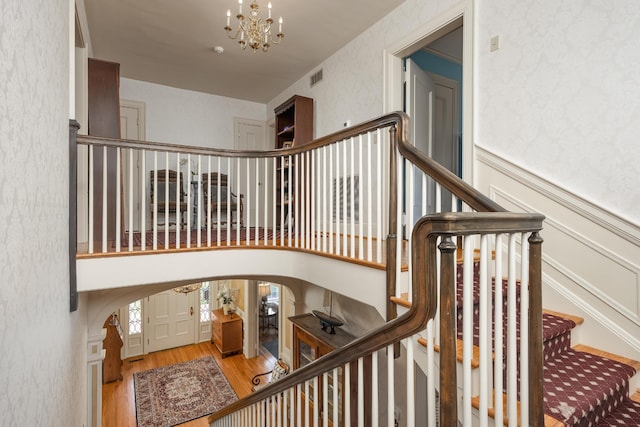 stairway featuring a notable chandelier and hardwood / wood-style flooring