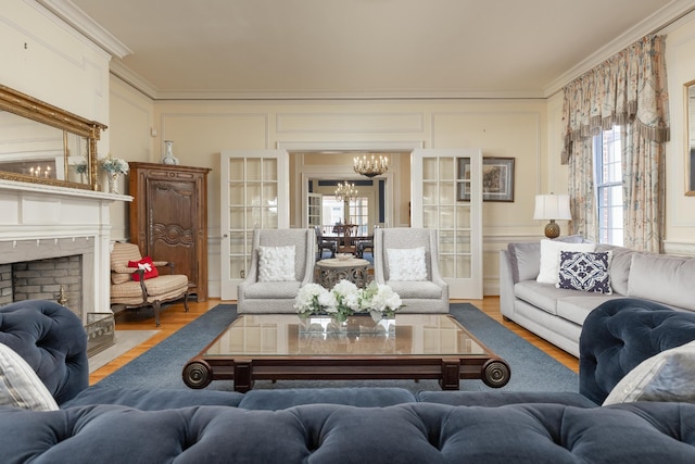 living room with wood-type flooring, crown molding, and an inviting chandelier