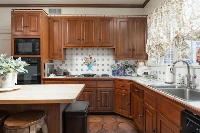 kitchen featuring decorative backsplash, black appliances, dark tile patterned floors, ornamental molding, and sink