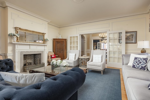 living room with hardwood / wood-style flooring, a chandelier, and ornamental molding