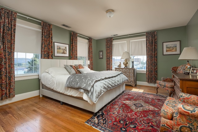 bedroom with multiple windows and light hardwood / wood-style floors