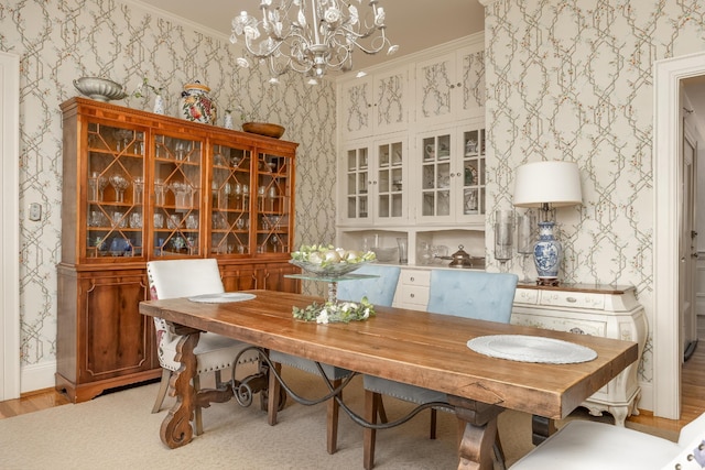 dining space featuring light wood-type flooring, a chandelier, and crown molding