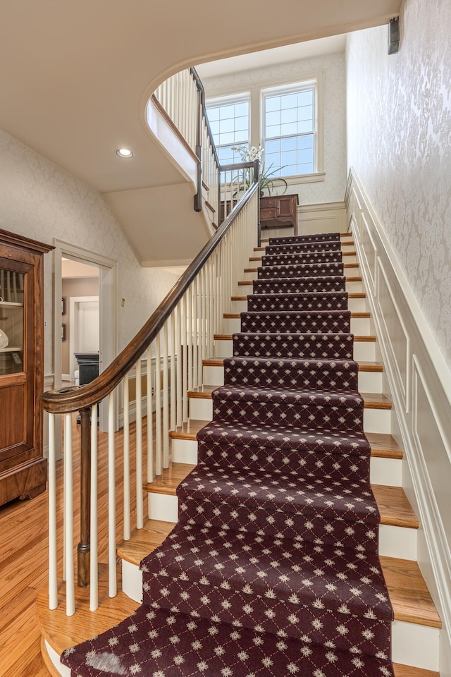 staircase featuring vaulted ceiling and hardwood / wood-style flooring