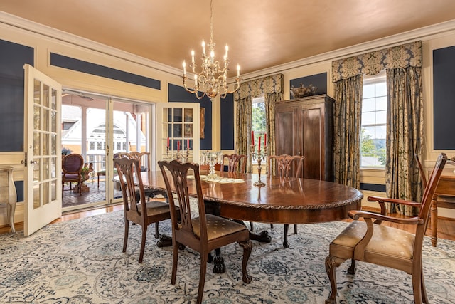 dining room featuring wood-type flooring, ornamental molding, a chandelier, and french doors