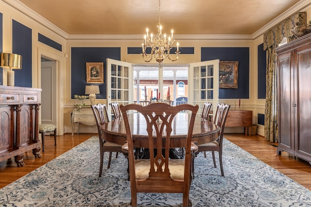 dining space featuring hardwood / wood-style flooring, a chandelier, and ornamental molding