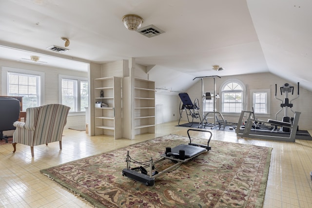 living room with built in shelves, lofted ceiling, and plenty of natural light