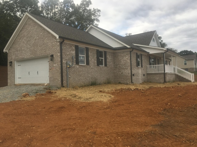 view of side of home with covered porch and a garage