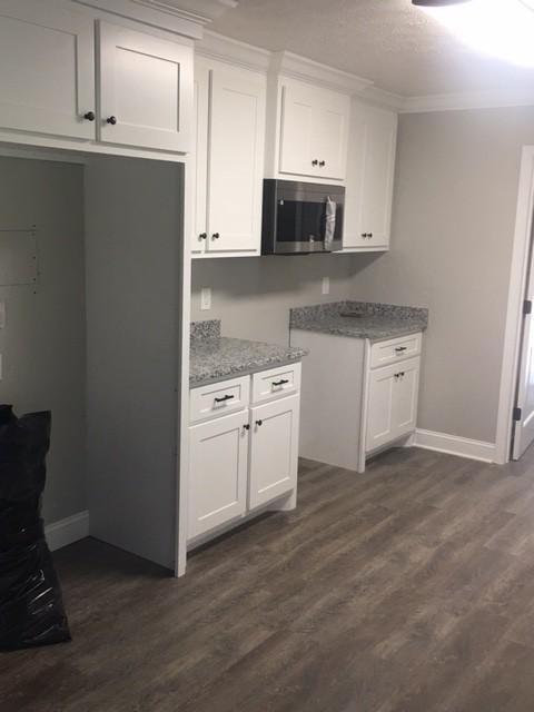 kitchen featuring white cabinetry, light stone countertops, and dark hardwood / wood-style floors