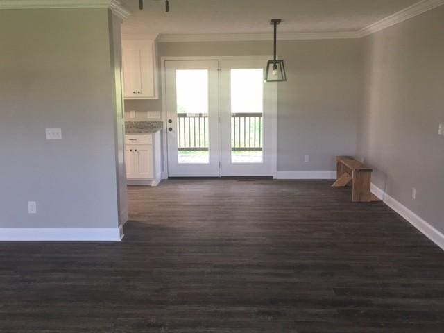 unfurnished dining area featuring dark hardwood / wood-style floors and ornamental molding