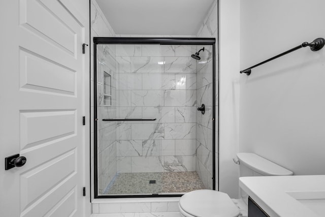 bathroom with toilet, an enclosed shower, and vanity