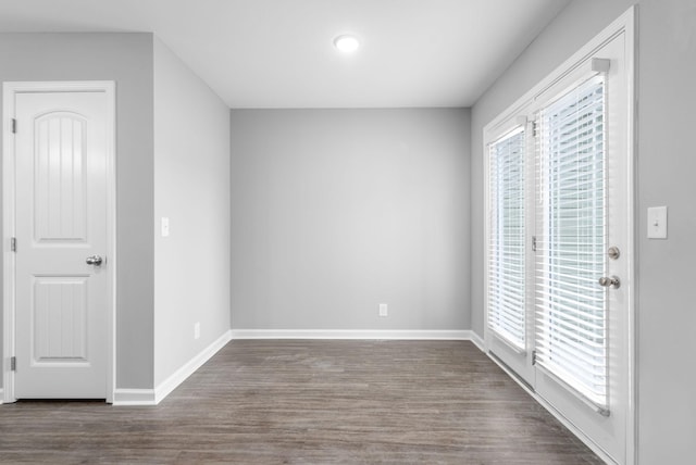 unfurnished bedroom with wood finished floors, access to exterior, and baseboards