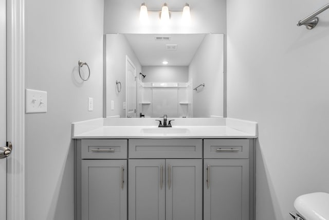 full bath with toilet, walk in shower, vanity, and visible vents