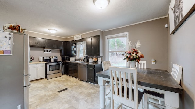 kitchen featuring stainless steel appliances, a textured ceiling, crown molding, dark brown cabinets, and sink