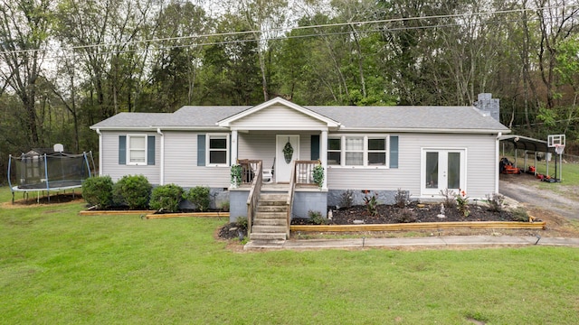 ranch-style home with a trampoline, a porch, and a front yard