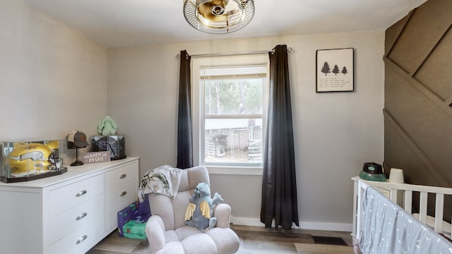 bedroom with a nursery area and light hardwood / wood-style floors