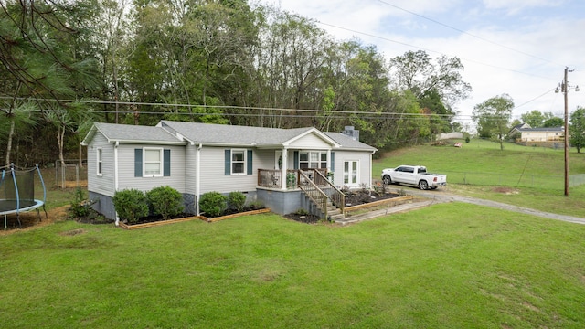 view of front of home featuring a front yard and a trampoline