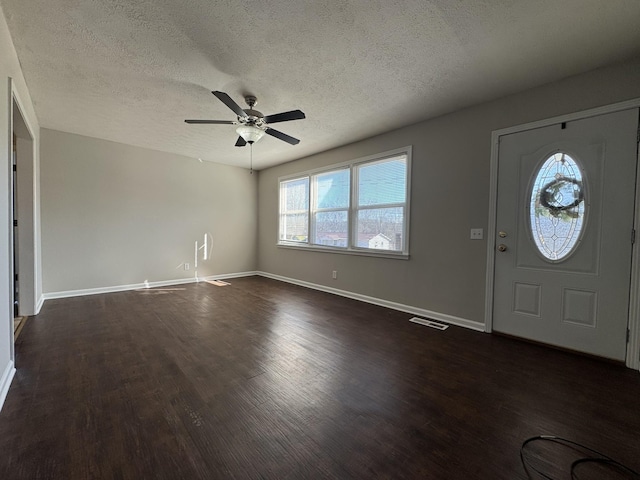 foyer with dark wood-style flooring, visible vents, ceiling fan, a textured ceiling, and baseboards