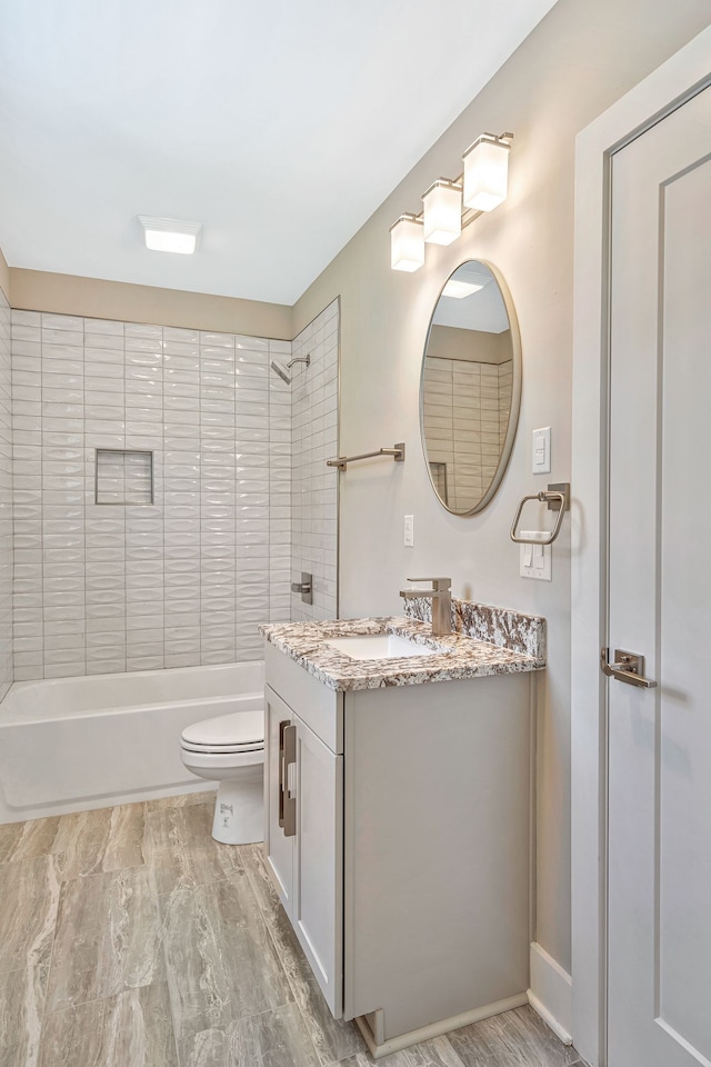 full bathroom with vanity, tiled shower / bath, and toilet