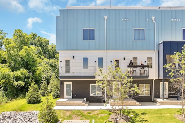 back of property featuring a patio and a balcony