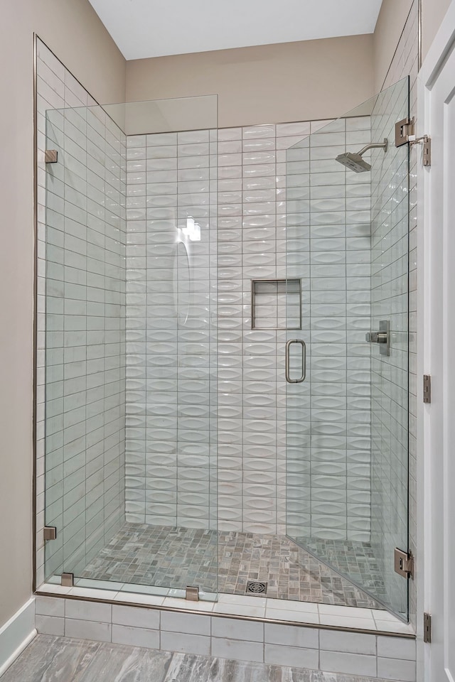 bathroom featuring a shower with door