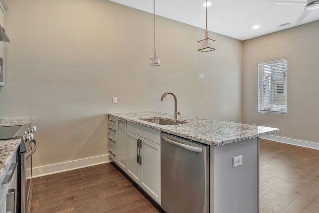 kitchen with hanging light fixtures, sink, dark wood-type flooring, white cabinetry, and stainless steel appliances