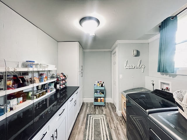 laundry room featuring dark wood-type flooring, independent washer and dryer, and crown molding