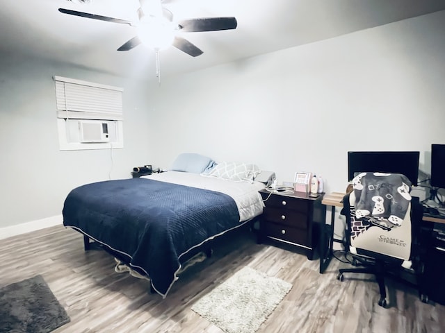 bedroom with hardwood / wood-style floors, cooling unit, and ceiling fan