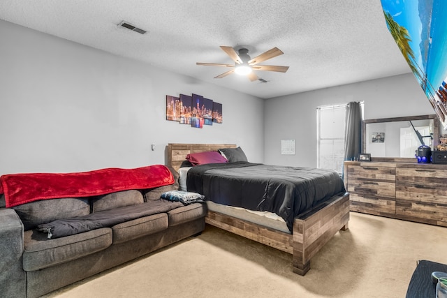 bedroom featuring ceiling fan, a textured ceiling, and carpet