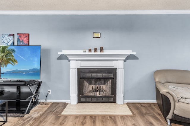 living room featuring a textured ceiling, ornamental molding, and hardwood / wood-style flooring