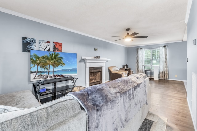 living room with ceiling fan, crown molding, and hardwood / wood-style floors