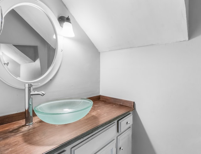 bathroom featuring lofted ceiling and vanity