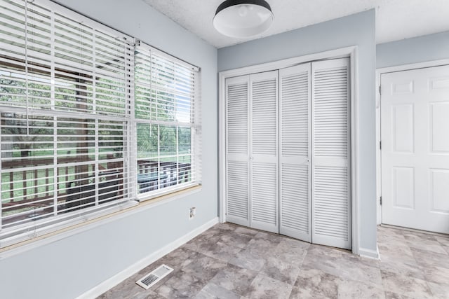 unfurnished bedroom with a textured ceiling and a closet