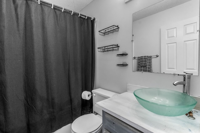 bathroom with walk in shower, vanity, toilet, and a textured ceiling