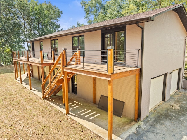 rear view of property with a wooden deck and a garage