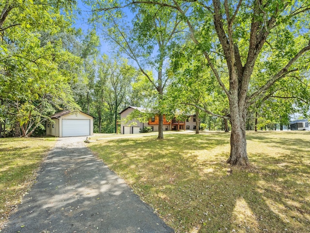 view of yard with a garage and an outbuilding